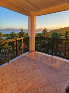 a balcony with a view of the ocean and palm trees at Appartement Nourou in Pamandzi