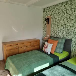 Un dormitorio con una cama verde y una pared cubierta de calabazas en Exklusive Ferienwohnung Hattorfer Teiche en Wolfsburg