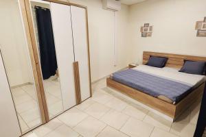a bedroom with a bed and a large mirror at Appartement Nourou in Pamandzi +4 photos