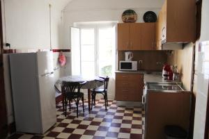 a kitchen with a table and a white refrigerator at Mont' Sobro House in Évora