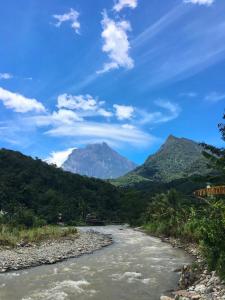 a river with a mountain in the background at Kadamaian Riverside Lodge Tambatuon, Kota Belud in Kota Belud