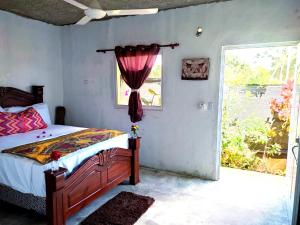 a bedroom with a bed and a window at Hotel i t a in Las Galeras