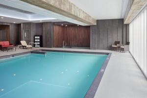 a swimming pool in a room with a table and chairs at Delta Hotels by Marriott Trois Rivieres Conference Centre in Trois-Rivières