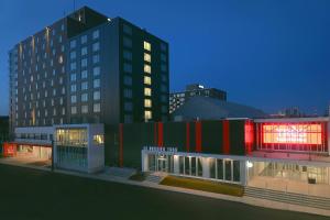 a building with a red and green facade with buildings at Delta Hotels by Marriott Trois Rivieres Conference Centre in Trois-Rivières