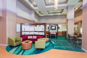 vestíbulo con sofá, mesas y sillas en SpringHill Suites by Marriott Peoria, en Peoria