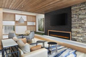 a living room with a fireplace and a tv at Fairfield Inn & Suites by Marriott Raleigh Wake Forest in Wake Forest