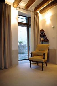 una silla amarilla en una habitación con ventana en Appartamento Corte Bragadin, en Venecia