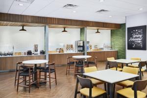 a restaurant with tables and chairs and a counter at Fairfield Inn & Suites by Marriott Raleigh Wake Forest in Wake Forest