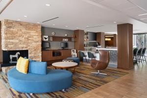 a living room with a blue couch and a fireplace at Fairfield Inn & Suites by Marriott Los Angeles LAX/El Segundo in El Segundo