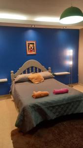 1 dormitorio con 1 cama grande en una pared azul en Casa de campo en Belén