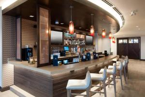 um bar com uma fila de cadeiras e um balcão em SpringHill Suites by Marriott Clearwater Beach em Clearwater Beach