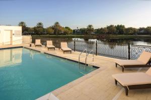 uma piscina com espreguiçadeiras ao lado de um corpo de água em The Karol Hotel, St. Petersburg Clearwater, a Tribute Portfolio Hotel em Clearwater