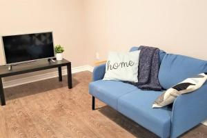 un sofá azul en la sala de estar con TV en Charming Studio with Parking, Netflix, Full Kitchen - Close to Algonquin College, en Ottawa