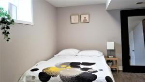 Un dormitorio con una cama con una pintura. en Charming Studio with Parking, Netflix, Full Kitchen - Close to Algonquin College, en Ottawa