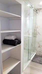 a walkin closet with a glass shower and towels at Charming Studio with Parking, Netflix, Full Kitchen - Close to Algonquin College in Ottawa