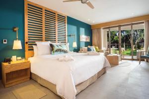 ein Schlafzimmer mit einem großen Bett mit blauen Wänden in der Unterkunft Dreams Natura Resort & Spa - All Inclusive in Puerto Morelos