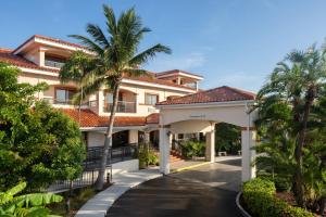 un edificio con una palmera y un camino de entrada en Courtyard by Marriott Key West Waterfront en Cayo Hueso