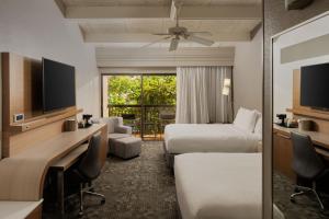 a hotel room with two beds and a desk at Courtyard by Marriott Key West Waterfront in Key West