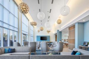 a waiting room with couches and tables and windows at Element Knoxville West in Knoxville