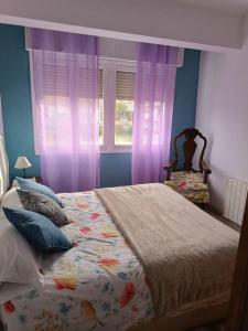 1 dormitorio con 1 cama y una ventana con cortinas moradas en Casa Oviedo centro en Oviedo