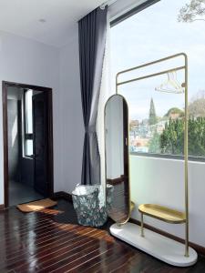 a mirror and a stool in a room with a window at Kaylin House in Xuan An