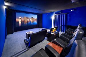 einen Kinoraum mit blauen Wänden und Stühlen und einem großen Bildschirm in der Unterkunft Hotel Atlantic Hamburg, Autograph Collection in Hamburg