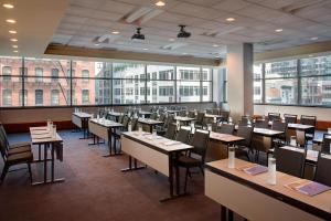 un comedor con mesas, sillas y ventanas en Residence Inn by Marriott New York Manhattan/Times Square, en Nueva York