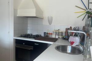 cocina con fregadero y fogones en Duplex of 90m near Montmartre, en París