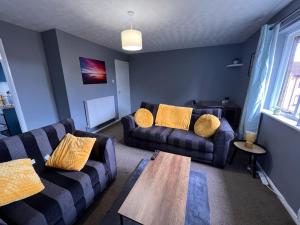 ein Wohnzimmer mit 2 Sofas und einem Holztisch in der Unterkunft Spacious Apartment with Parking in Norwich