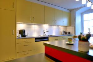 uma cozinha com armários amarelos e uma ilha vermelha em BnB Elsenerhaus 
