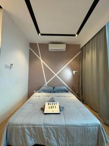 a bedroom with a bed with a first knot sign on it at Blest Loft 12 Manhattan Suites ITCC in Penampang