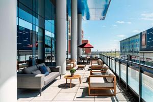 balkon z kanapami i stołami w budynku w obiekcie Toronto Marriott Markham w mieście Markham