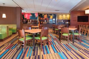 una sala da pranzo con tavoli, sedie e un bar di Fairfield Inn & Suites by Marriott Indianapolis Fishers a Fishers