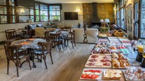 una habitación con mesas y sillas con comida. en Roca Blanca en Espot