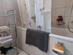 a bathroom with a shower curtain with birds on it at BnB Elsenerhaus 