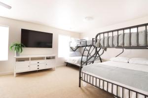 ein Schlafzimmer mit einem Etagenbett und einem Flachbild-TV in der Unterkunft Red Sands Retreat with Pool Pickleball and Zion NP in Washington