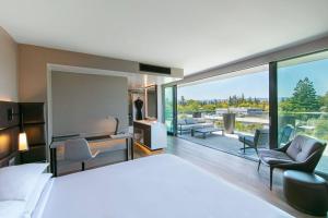 a bedroom with a large bed and a living room at AC Hotel by Marriott Palo Alto in Palo Alto