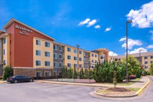 a apartment building with a car parked in a parking lot at Residence Inn by Marriott Florence in Florence