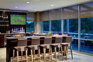 a bar with a bunch of stools in a room with windows at SpringHill Suites by Marriott South Bend Notre Dame Area in South Bend
