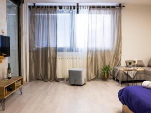 a living room with a bed and a large window at Center Cozy Apartment in Subotica
