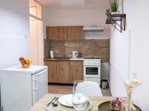 een keuken met een tafel en een keuken met een fornuis bij Center Cozy Apartment in Subotica