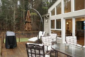 a patio with a table and chairs and an umbrella at Woodland Hills Modern Cottage Minutes from Downtown Great Barrington in Great Barrington