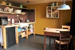 een keuken met een tafel en een eetkamer bij 't Prentenhokkie in Stuifzand