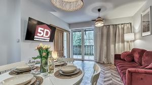 een woonkamer met een tafel en een rode bank bij Apartament Angelika F3 z klimatyzacją dla 8 osób - 5D Apartamenty in Świeradów-Zdrój