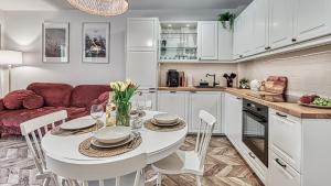 een keuken met een witte tafel en een rode bank bij Apartament Angelika F3 z klimatyzacją dla 8 osób - 5D Apartamenty in Świeradów-Zdrój