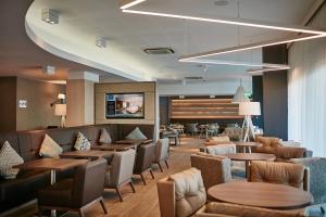 AC Hotel by Marriott Manchester Salford Quays في مانشستر: مطعم بطاولات وكراسي وبهو