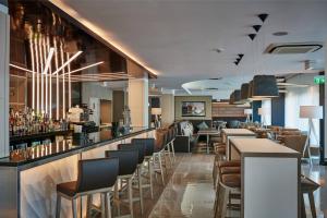 a restaurant with a bar with chairs and tables at AC Hotel by Marriott Manchester Salford Quays in Manchester