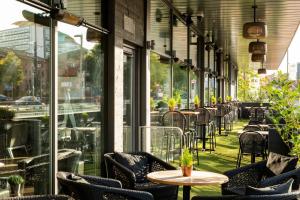 un restaurante vacío con mesas, sillas y ventanas en AC Hotel by Marriott Manchester Salford Quays, en Mánchester