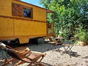 een cabine met stoelen en een tafel en stoelen bij La Roulotte du Herdal in Profondeville
