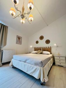 una camera con un grande letto e un lampadario a braccio di Villino in Campagna con Piscina Relax - La Casa di Teresa a Campomarino